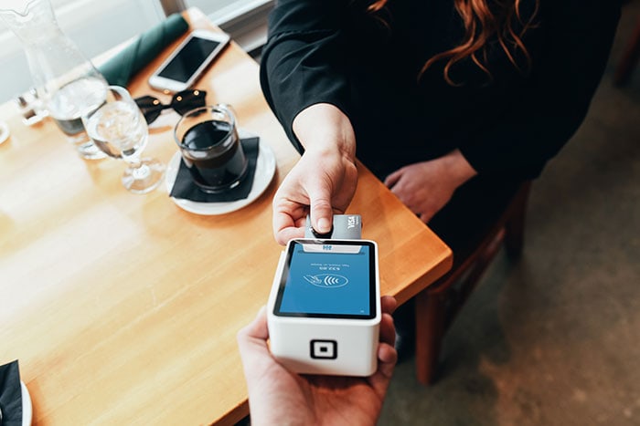 Where to Exchange Currency - woman charging meal with credit card