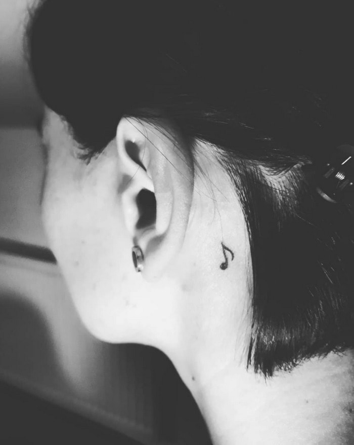 Minimalist cat tattoo behind the ear